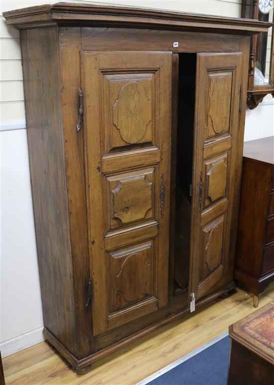 A 19th century French provincial oak armoire, fitted two doors with cartouche-shaped panels W.143cm